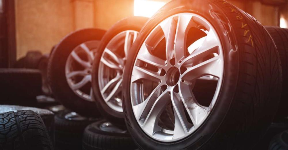 A stockroom with a bunch of wheels. Three of the wheels are sitting upright on stacks of other wheels.