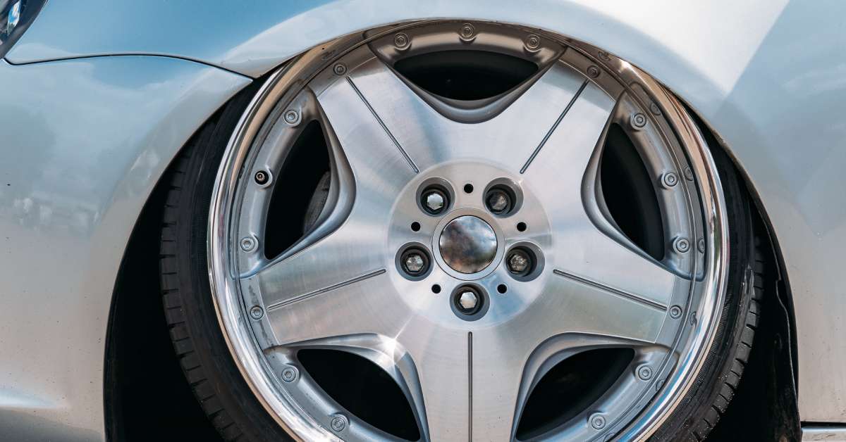 A vehicle with a large rim. The rim is so big that the wheel extends upward and inside of the wheel well.